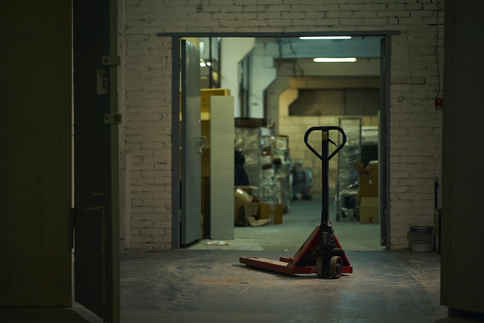 Manual pallet jack in an older workshop setting that has been abandoned for newer equipment